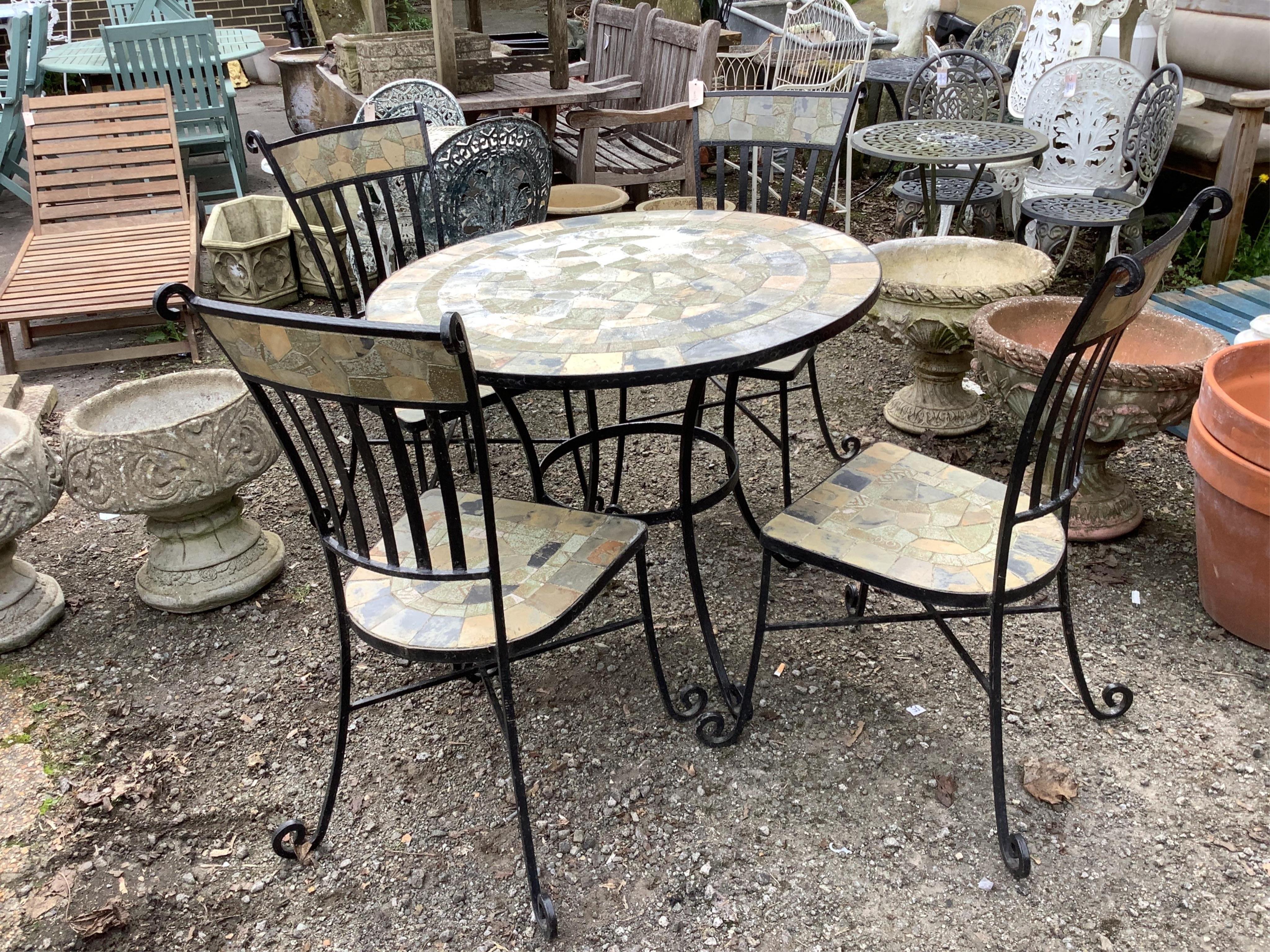 A circular wrought iron tiled top garden table, diameter 91cm, height 76cm together with four matching chairs